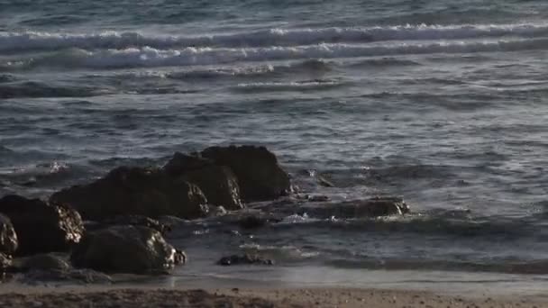 Волны мягко плескающиеся над скалами на средиземноморском пляже — стоковое видео