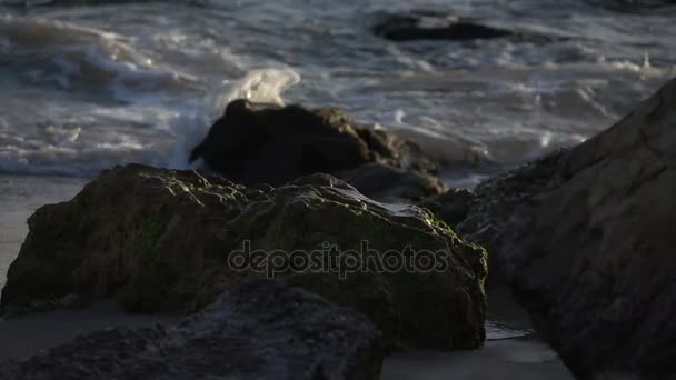 Zwolnionym tempie fale rozpryskiwania na szczycie skały na plaży — Wideo stockowe