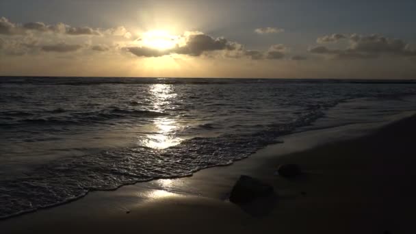Яскравий захід сонця на горизонті над повільний рух хвиль на пляжі — стокове відео