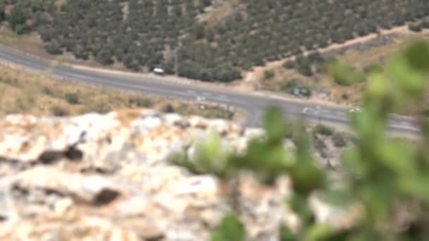 Weergave van auto's op de weg ver onder de bergtop — Stockvideo