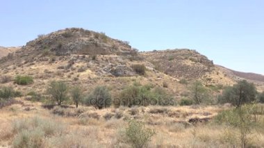 Arka planda büyük tepe ile çorak manzara 