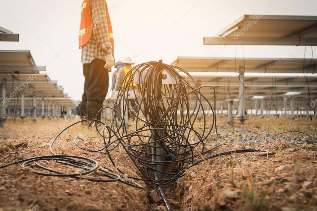 engineer and electrician installing solar tracking power plant; scope of work at solar power plant tracking to sun