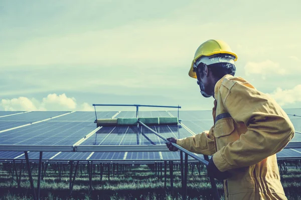 technician operating and cleaning solar panels at generating pow