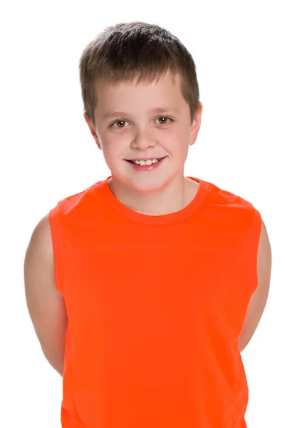 Smiling young boy in an orange shirt — Stock Photo, Image