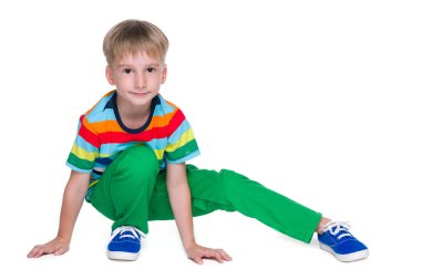 Yeşil pantolon içinde küçük çocuk oturur