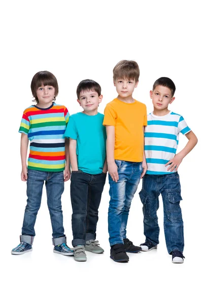 Cuatro chicos jóvenes de moda están de pie juntos — Foto de Stock
