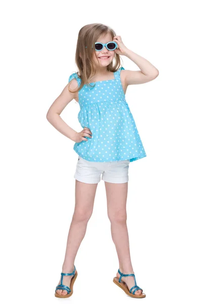 Fröhliches kleines Mädchen in einem gepunkteten blauen Kleid — Stockfoto