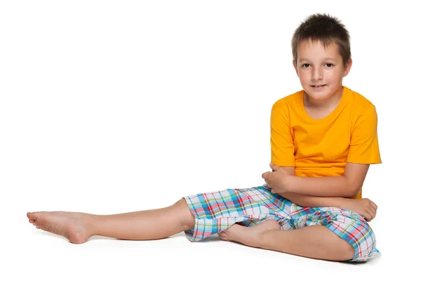 Lindo niño sonriente se sienta — Foto de Stock