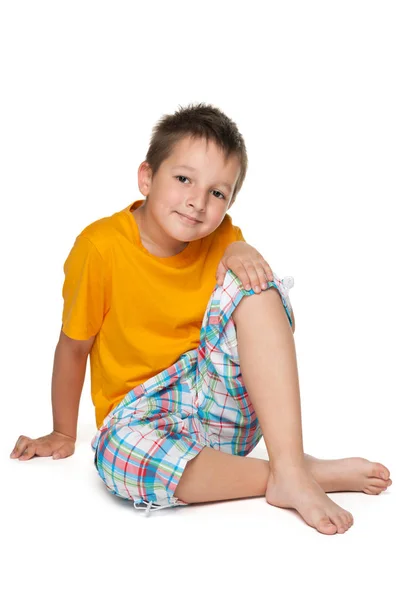 Little boy in the yellow shirt sits — Stock Photo, Image