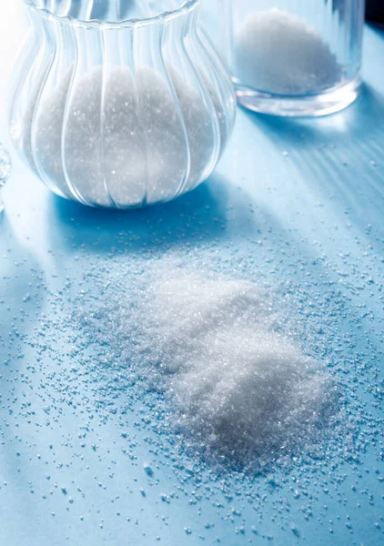 Closeup Scattered Sugar Sugar Glass Bottle Blue Background — Stock Photo, Image