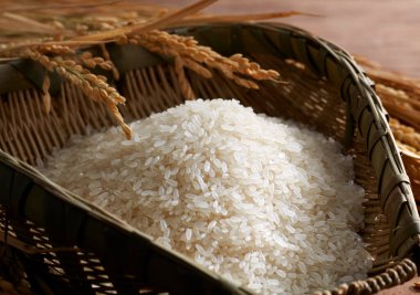 Rice in dustpan on wooden background clipart