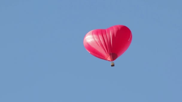 Röd ballong i form av ett hjärta i den blå himlen — Stockvideo