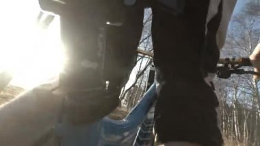 Sonbahar parkında yokuş aşağı bisiklete binen ekstrem bir sürücü. Yavaş çekim videosu 2x