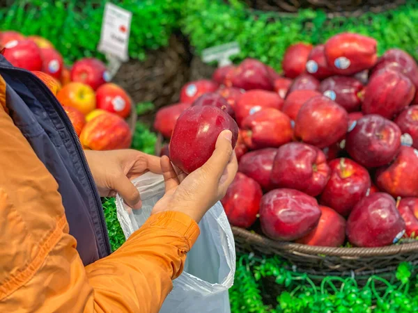 Γυναίκα που αγοράζει και βάζει ένα μήλο στη βιολογική πλαστική σακούλα — Φωτογραφία Αρχείου