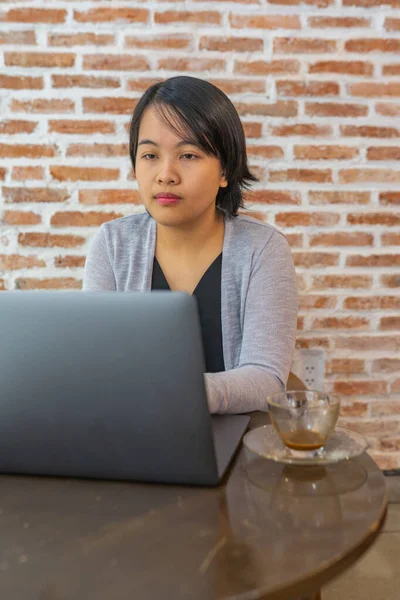 Foto vertical de la mujer trabajando y mirando la pantalla del ordenador portátil — Foto de Stock