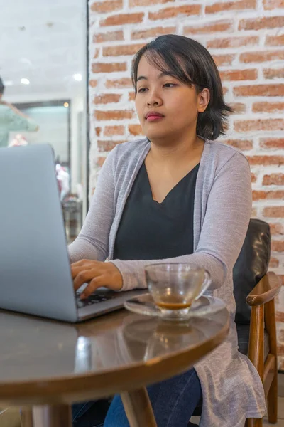 Foto vertical de la mujer que trabaja en el ordenador portátil en la mesa de café — Foto de Stock