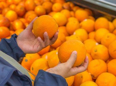 Meyve dükkanından portakal alan bir kadın