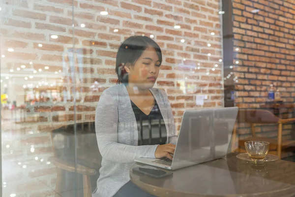 Asiática freelancer mujer usando laptop en café tienda — Foto de Stock