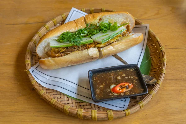 Délicieuse banh mi vietnamienne sur plateau traditionnel en rotin au restaurant — Photo