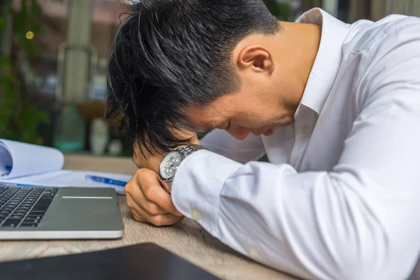 Unavený podnikatel sedí s notebookem a dokumenty v kanceláři — Stock fotografie