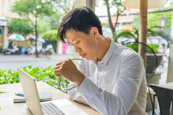 Hombre asiático en camisa blanca trabajando en portátil en la cafetería — Foto de Stock