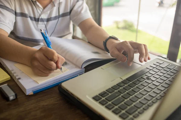 Diák írás jegyzet és a laptop használata tanulás közben — Stock Fotó