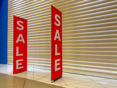 Alışveriş merkezinin kapanış noktasında büyük indirim afişi asılı.