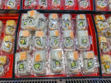 Süpermarkette satılık Japon pirinç topu suşisi yığını.