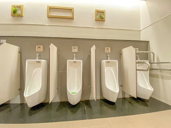 Casa de banho dos homens com mictórios de porcelana branca e limpa em linha — Fotografia de Stock