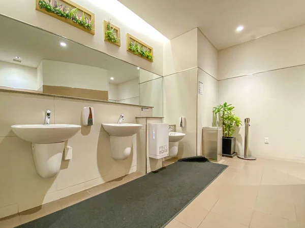 Speglar och tvättställ på tom offentlig toalett — Stockfoto