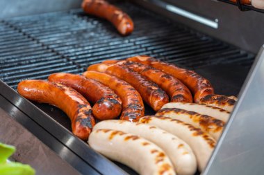 Lezzetli Alman sosisi barbekü kömüründe ızgara.