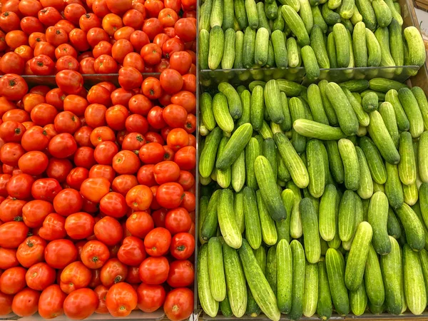 Большая куча красных помидоров и свежих огурцов в гипермаркете — стоковое фото