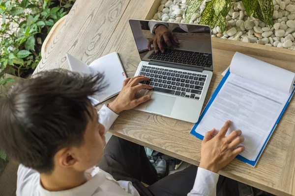 Asiatico businessman reading report e working su laptop — Foto Stock