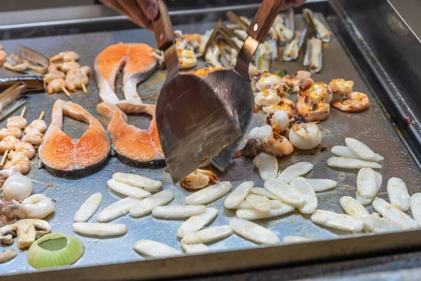 식당 주방에서 여러 가지 해산물을 조리할 때 스 패 툴라를 사용하는 요리사 — 스톡 사진