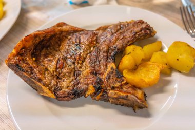 Bir tabak lezzetli ızgara biftek ve kızarmış patates.