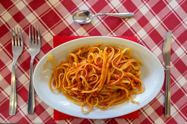 Над видом на спагетти и томатный соус на обеденном столе — стоковое фото