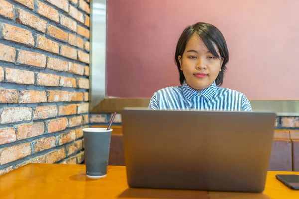 Joven mujer asiática freelancer trabajando en el portátil en el espacio de co-trabajo — Foto de Stock