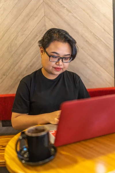 Joven asiática lesbiana trabajando en portátil y tomando café — Foto de Stock