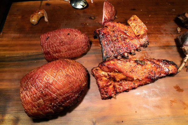Presunto assado e costelas de porco grelhadas tábua de cortar madeira — Fotografia de Stock