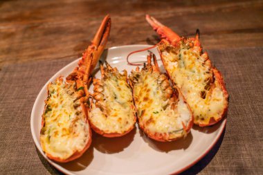 Lezzetli ızgara ıstakoz ve beyaz tabakta peynir.