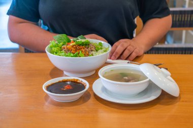 Vietnam restoranında leziz erişte çorbası ve taze sebzeler.