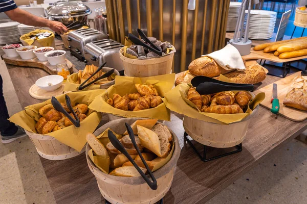 Koše croissantů a chlebů v bufetu na snídani v hotelu — Stock fotografie