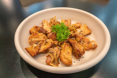 Maydanozla süslenmiş soya soslu Kore usulü kızarmış tavuk. 