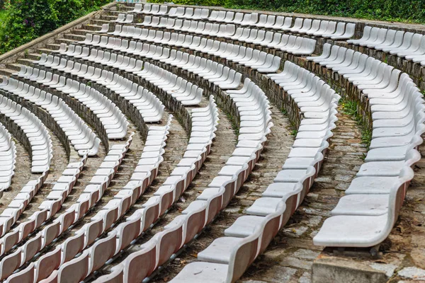 White plastic chairs in rows at outdoor stadium