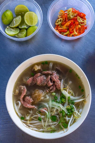 Ciotola di zuppa di tagliatelle di manzo Pho vietnamita presso il venditore alimentare — Foto Stock