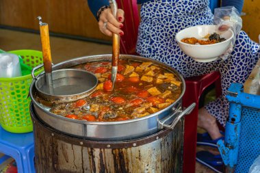 Vietnamlı Bun Rieu şehriye çorbası yapan bir kadın.