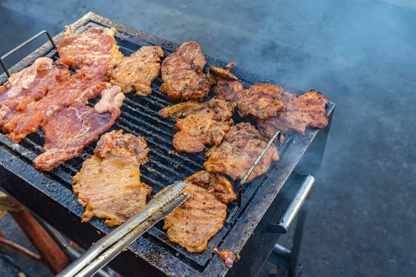 Grillowanie marynowanego kotleta wieprzowego na patelni węglanowej — Zdjęcie stockowe