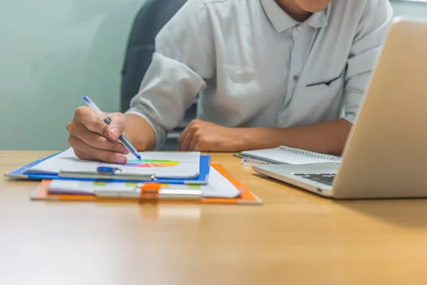 Man hand med penna för att kontrollera det ekonomiska numret på dokumentet — Stockfoto