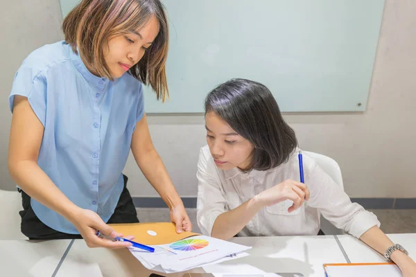 Zwei Büroangestellte sprechen über Verkaufstabelle — Stockfoto