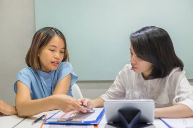 Asyalı çalışanlar ofiste iş hakkında tartışıyorlar